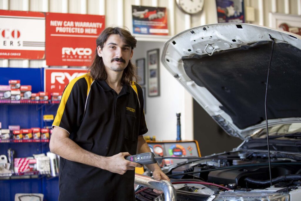Technician inspecting car engine at Pascoe Mechanical Bayside